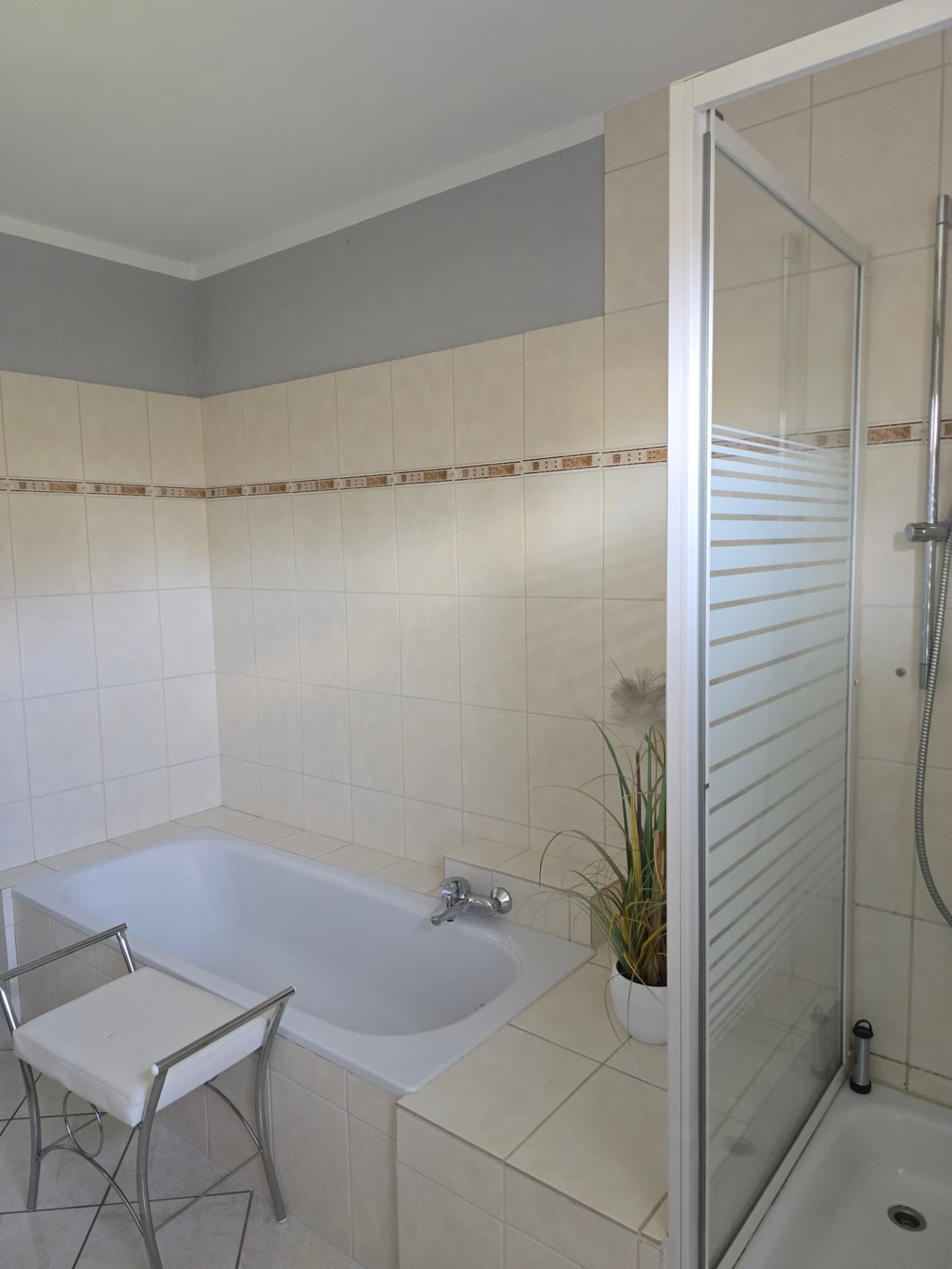Badewanne mit Sitzbank und Duschkabine im Badezimmer
