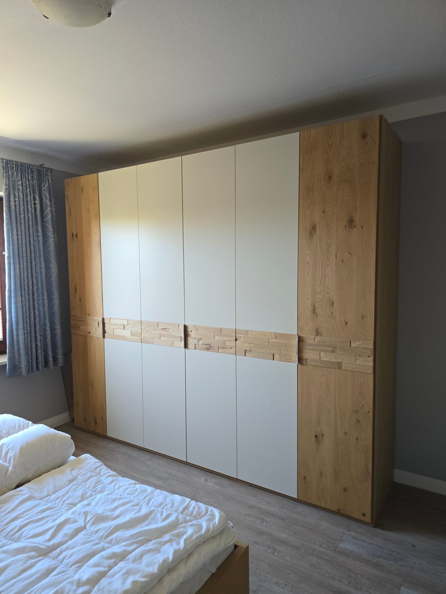Doppelbett mit Nachttischen, Lampen und Wandregalen im zweiten Schlafzimmer